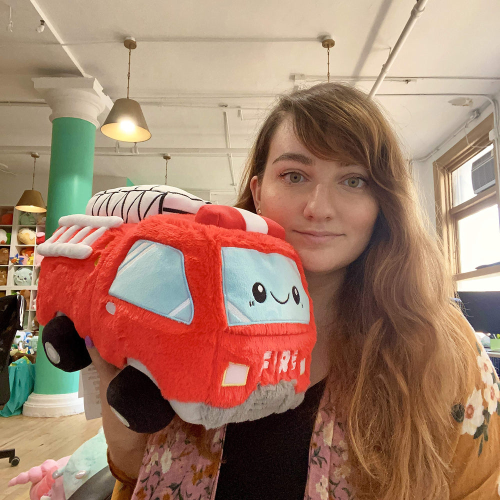 Squishable GO! Fire Truck held in hand illustrating portable comfort for travel and play