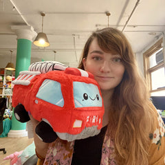 Squishable GO! Fire Truck held in hand illustrating portable comfort for travel and play