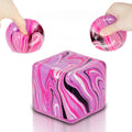 Ssqauvig squishy cube pink in hand, ideal for portable stress relief during commutes