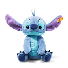Steiff Stitch plush face close-up shows blue fur and signature button-in-ear.