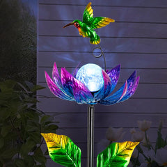 Sunnylight solar wind spinner with cracked glass ball glowing purple at dusk.