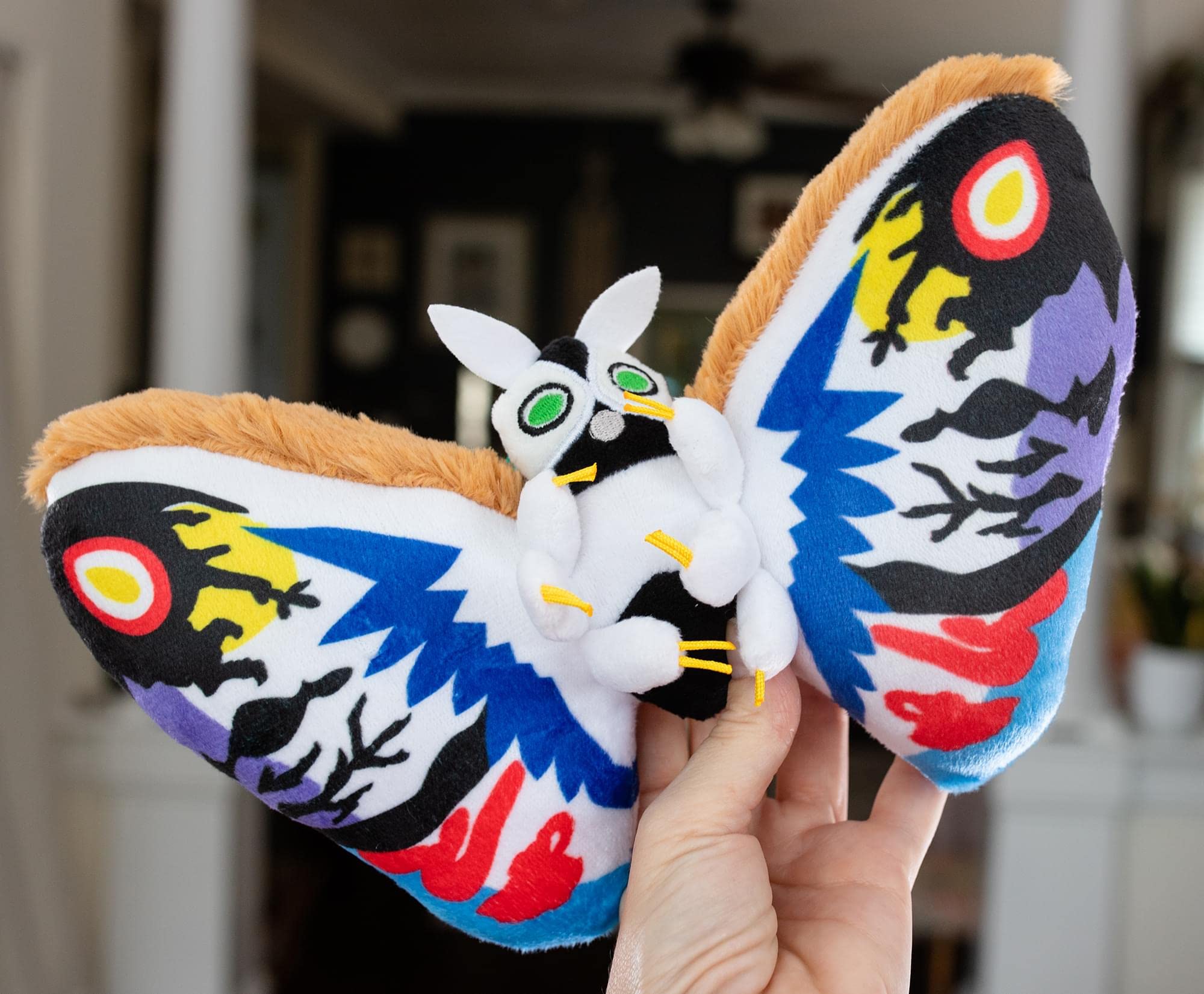The 10-inch Rainbow Mothra plush is ideal for shelves or quick hugs.