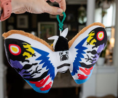 Rainbow Mothra plush joins Godzilla fan memorabilia with vivid colors.