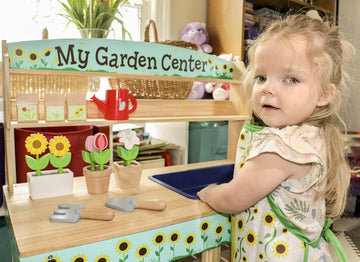 Svan Bloom & Grow apron helps organize accessories during busy pretend sessions.