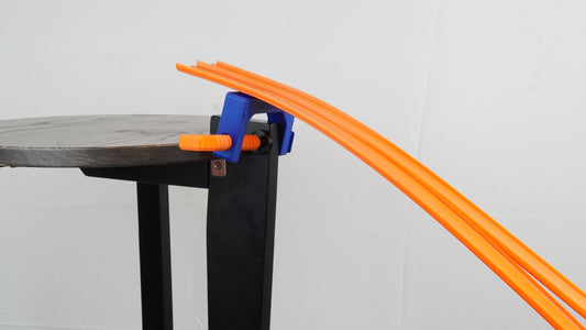 TechConnext track clamp securing tracks to table surfaces for stable races.