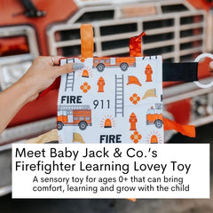 The Learning Lovey fire lovey attached to a stroller clip for on-the-go sensory play