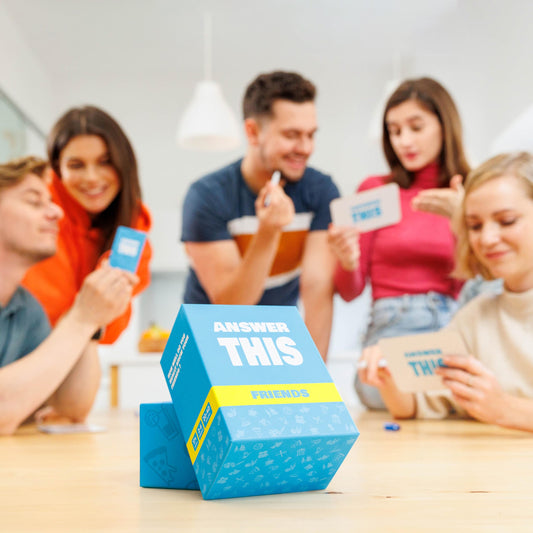The World Game Answer This Friends playing setup with players laughing around a table.