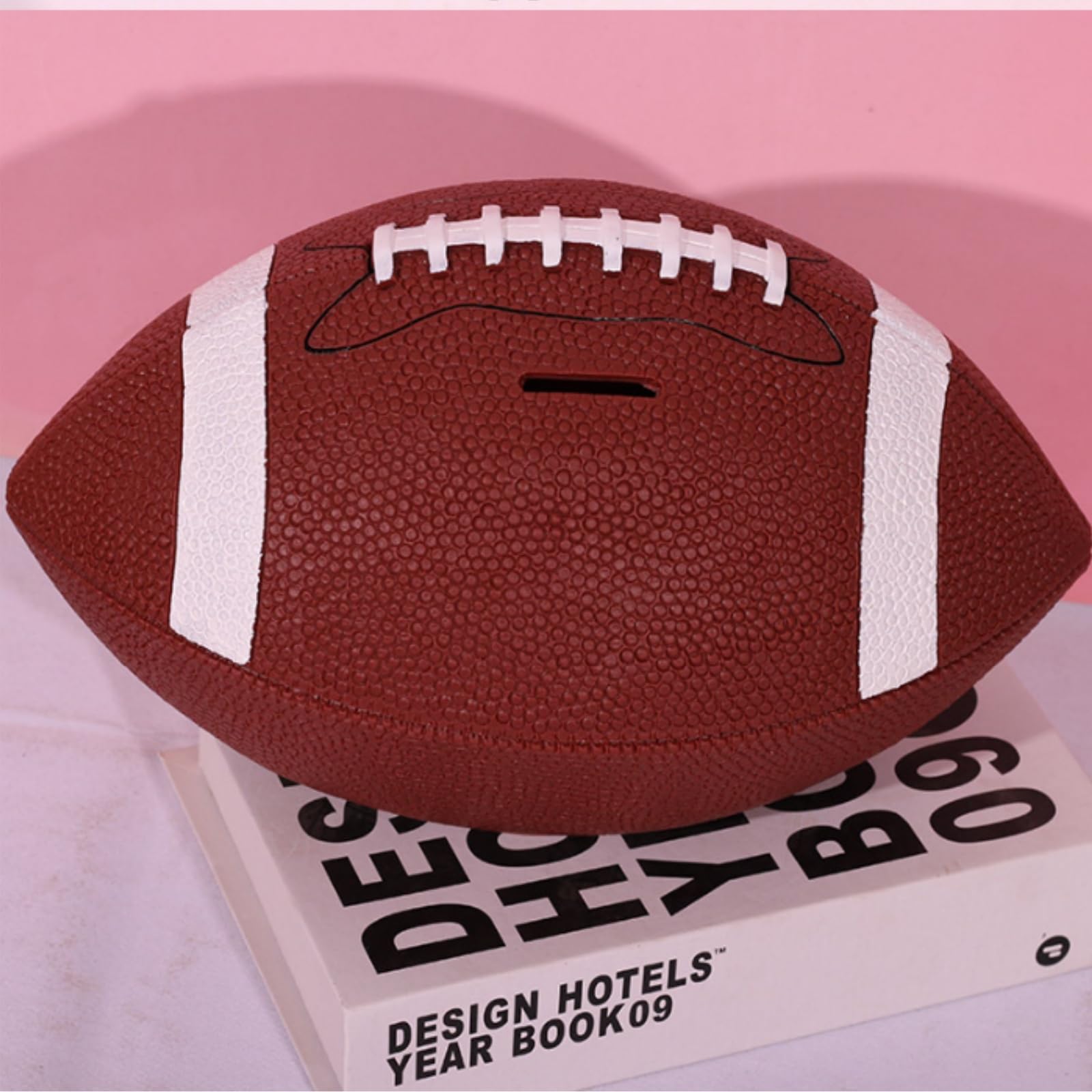 Tlence football bank bottom plug emphasizes simple coin removal.