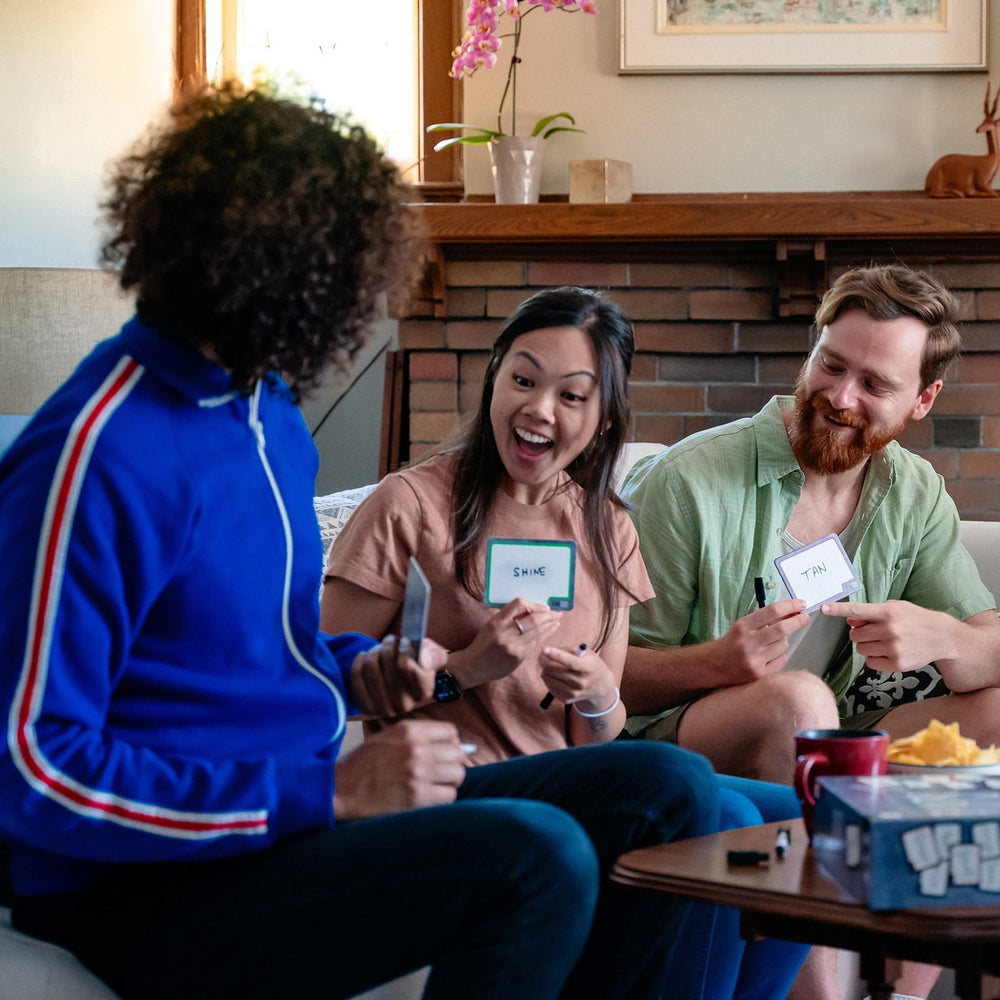 Lively group playing USAOPOLY Blank Slate during a family gathering.