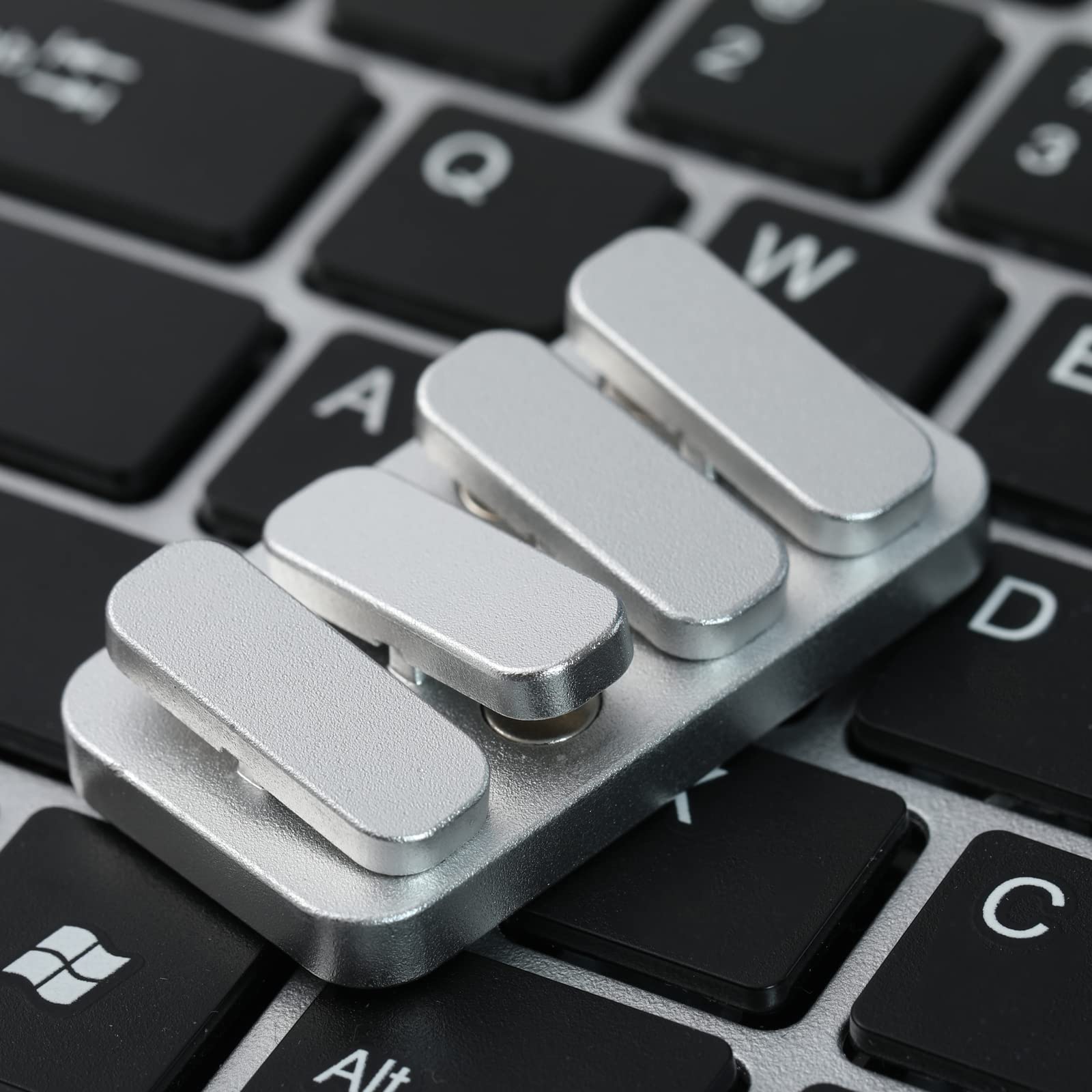WSHWXY metal fidget slider on desk, a stylish office accessory for tactile play.