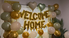 Xinvery gold welcome home foil banner provides a polished celebration backdrop.