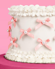xo Fetti pink bow pearl toppers with clear spikes for easy insertion