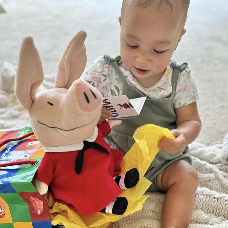 Removable dress feature on Olivia pig plush adds play value.