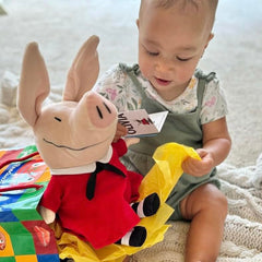 Removable dress feature on Olivia pig plush adds play value.